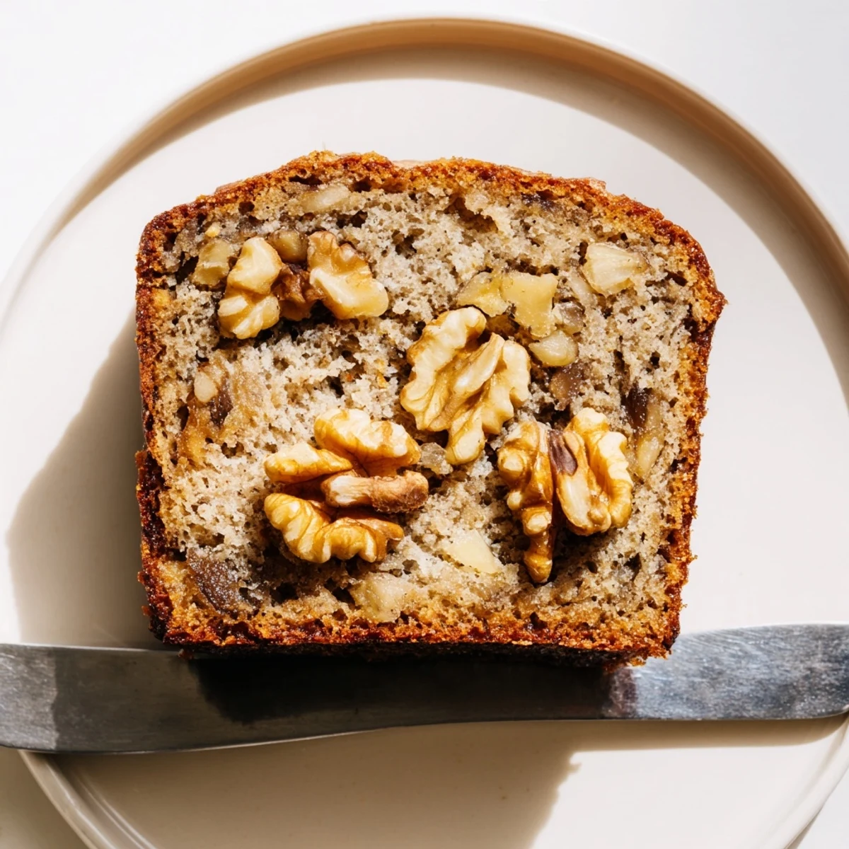 Moist classic banana bread with walnuts, perfect for breakfast or afternoon snacks.  