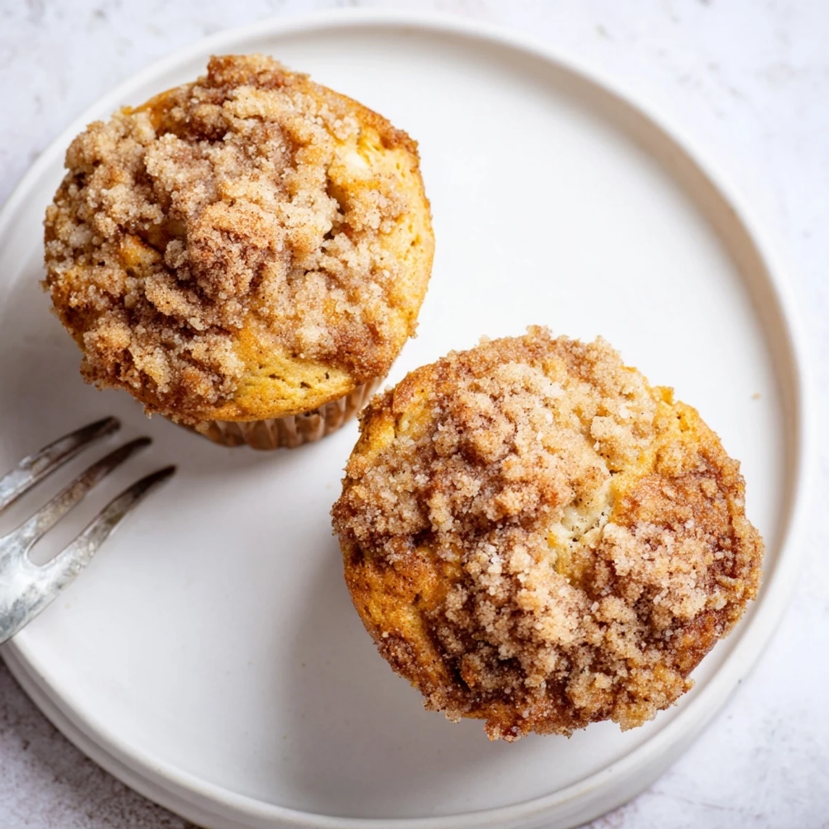 Golden-brown Apple Cinnamon Streusel Muffins, bursting with tender apple pieces and spices.