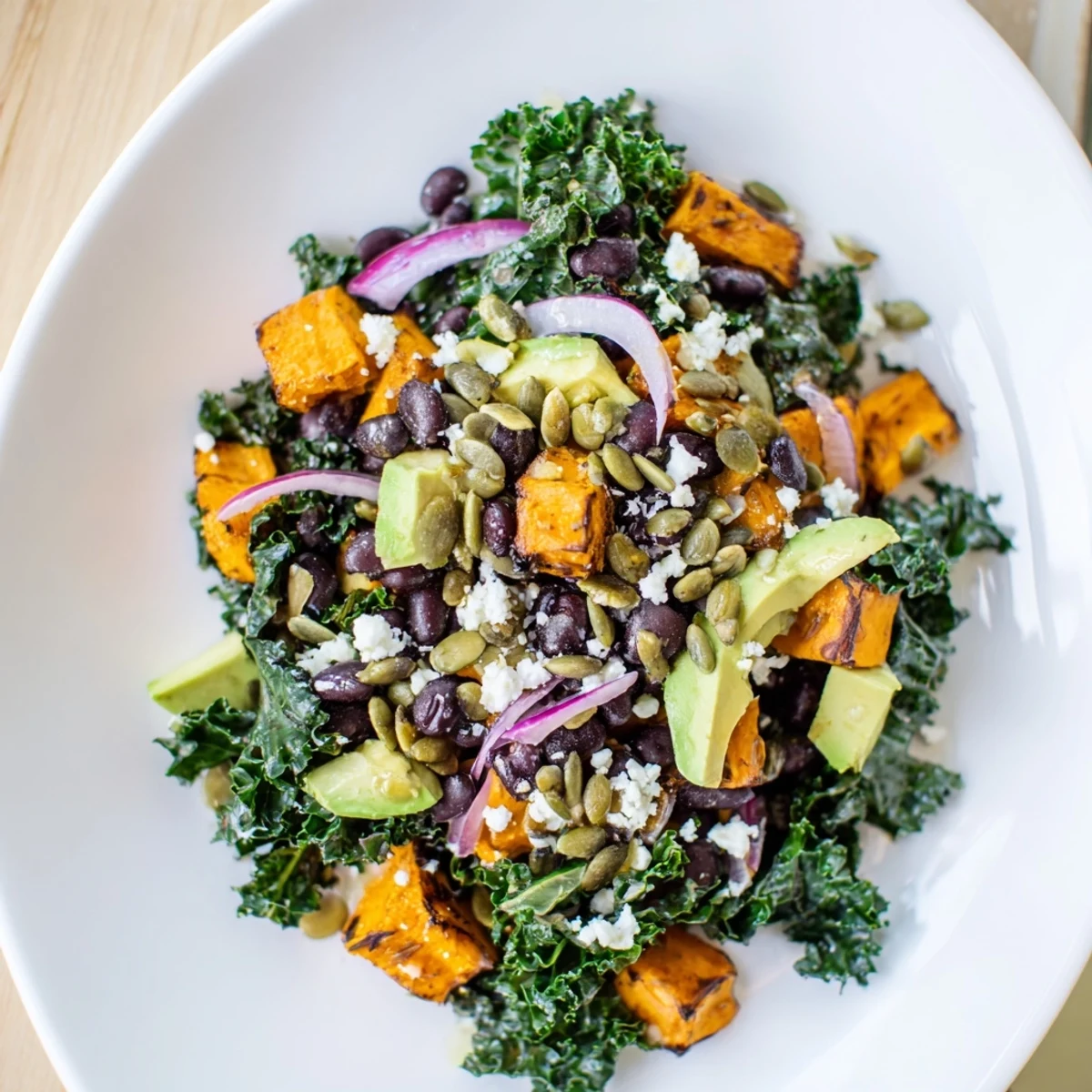 Enjoy a delicious serving of Massaged Kale Salad with pumpkin seeds, a perfect vegetarian meal.