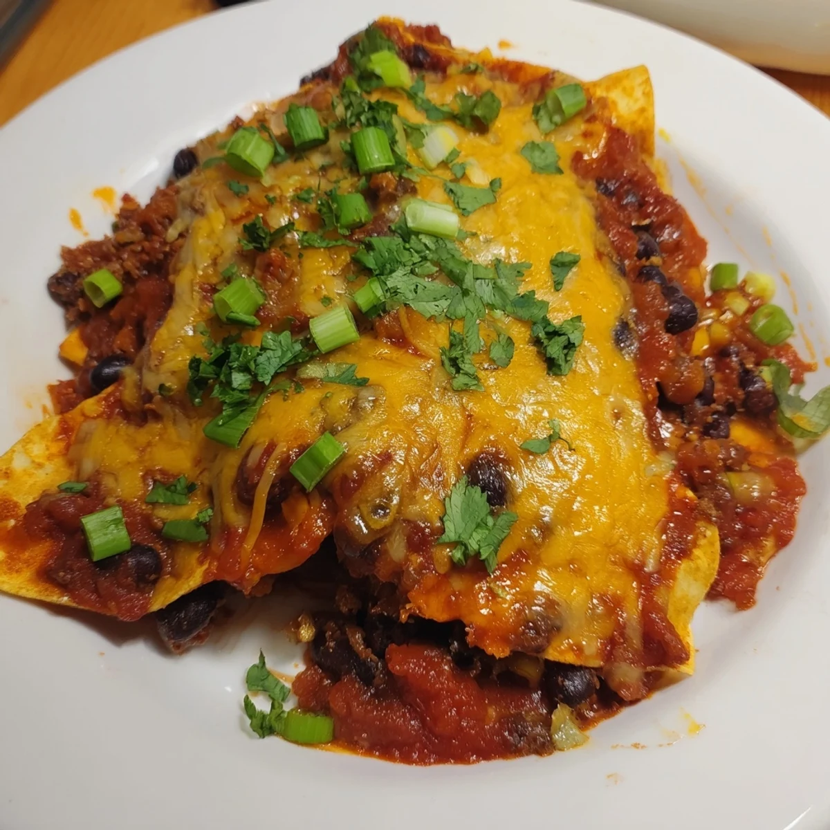 Looking delicious: freshly-baked Cheesy Bean Enchiladas with a hearty bean filling and vibrant green onions.