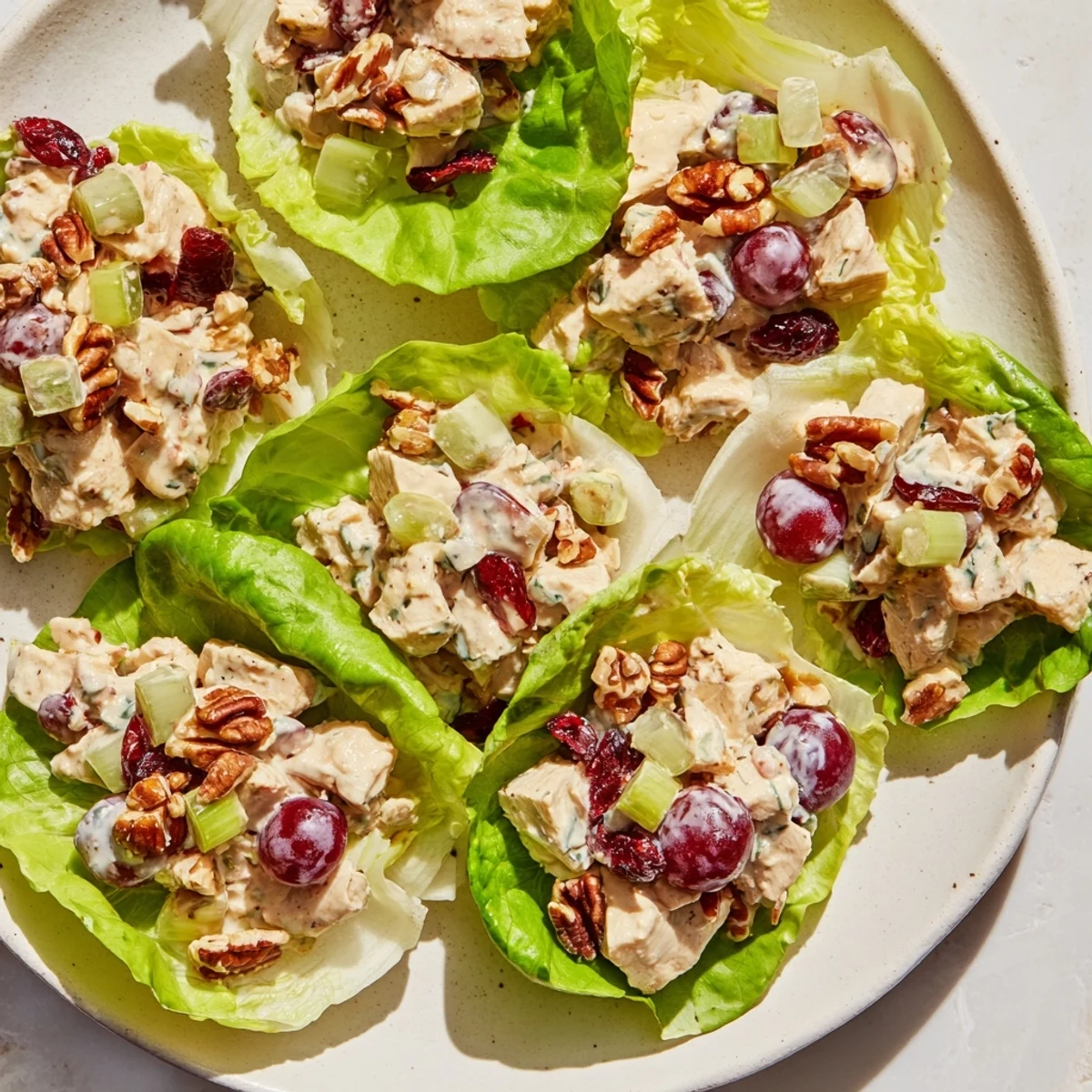 Fresh, colorful arrangement of Simplified Festive Chicken Salad Cups served on crisp lettuce for an appetizer.