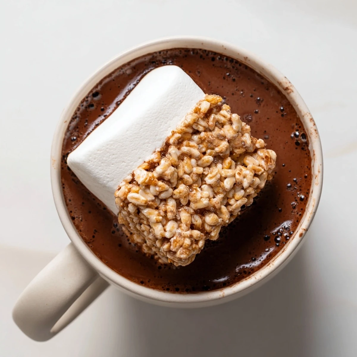 Steaming hot chocolate recipe topped with a melting, golden marshmallow bar; a comforting treat.