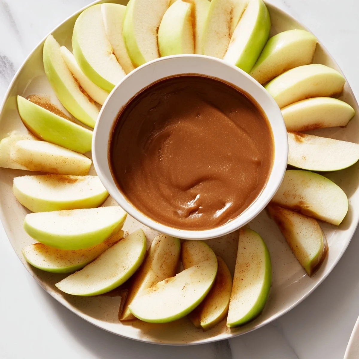 Golden apple slices surrounding a luscious, homemade caramel dip, ready for dipping.