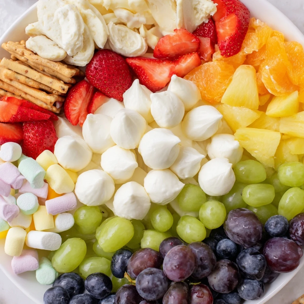 This festive Cloud & Rainbow Grazing Board presents a whimsical arrangement of treats to delight children and guests.