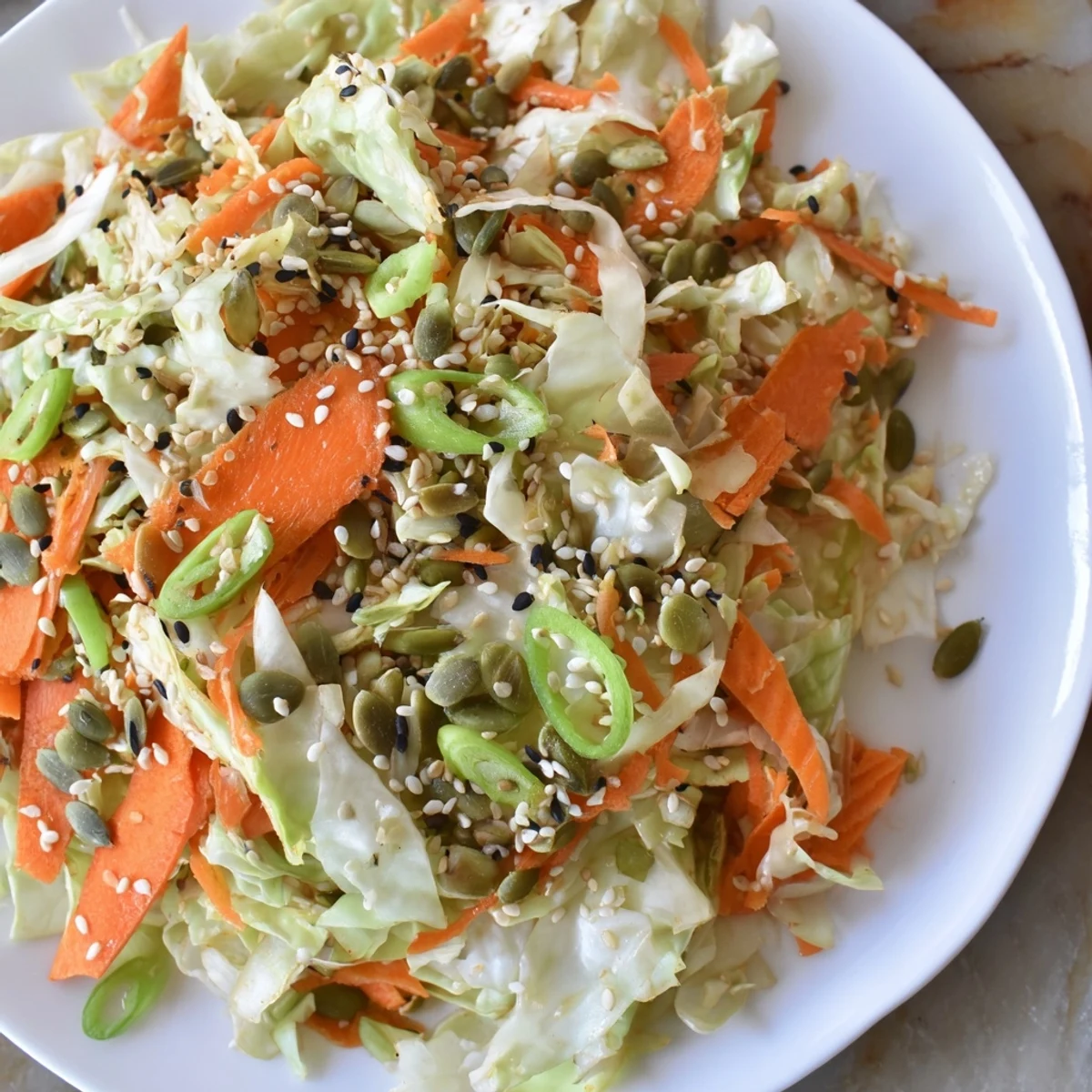 Freshly tossed cabbage-core slaw salad, with a nutty sesame dressing and toasted seeds, ready to serve.