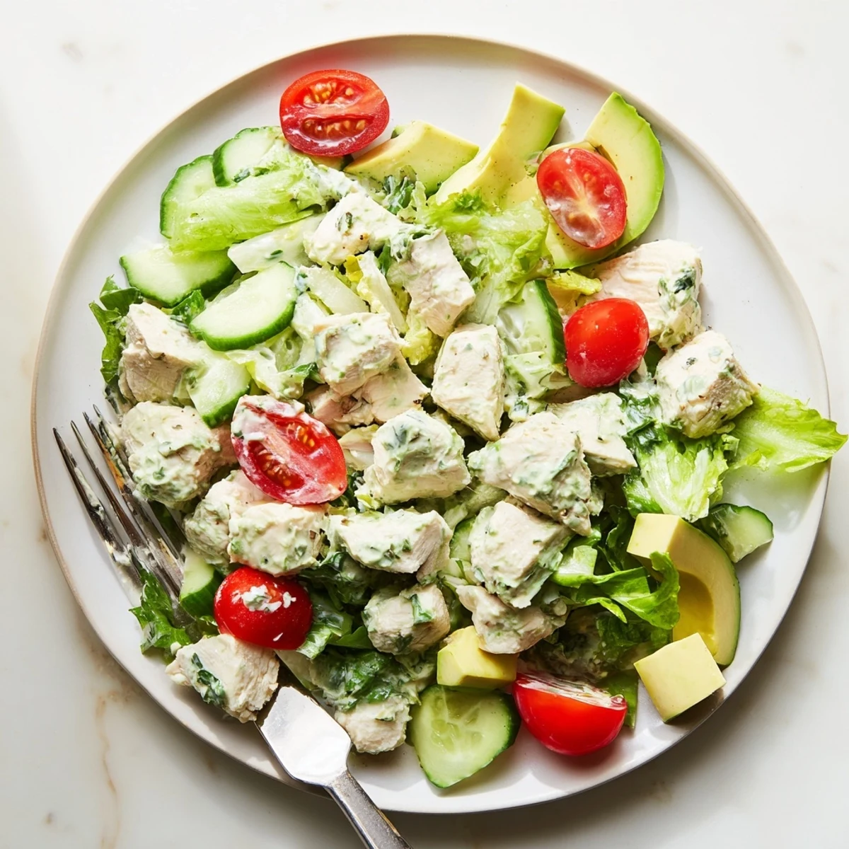 Tender chunks of baked chicken coated in creamy Green Goddess dressing, served over fresh mixed greens with cherry tomatoes and cucumber.