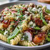 Colorful spring pasta salad with tender asparagus, snap peas, and radishes, tossed in a zesty lemon vinaigrette for a fresh, healthy meal.  