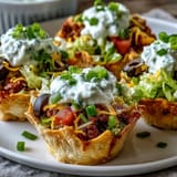 Individual Easy Taco Dip Cups feature colorful layers of seasoned cream cheese, lettuce, tomatoes, and cheddar in clear cups.  