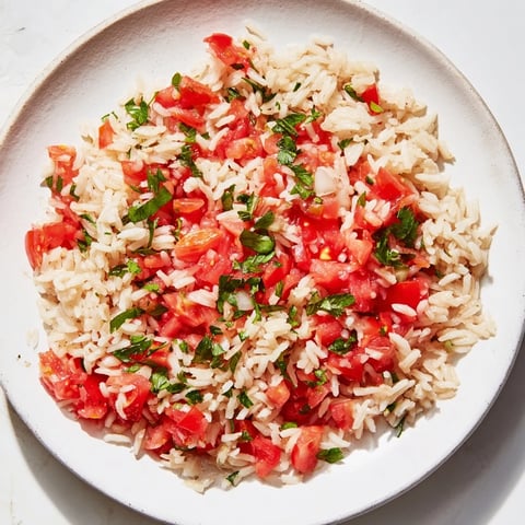Steaming hot Tomato-Rice Skillet Dinner, a comforting one-pan meal with fresh parsley garnish.