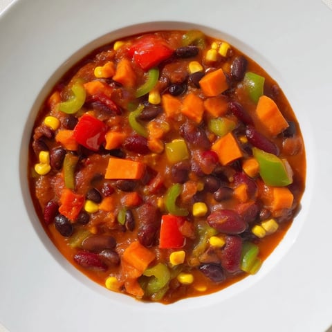 Steaming veggie chili, vibrant with colorful vegetables and spices, ready to serve with toppings.