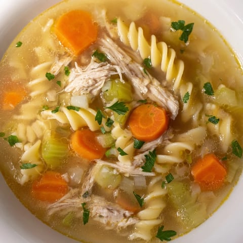 Crockpot Chicken Noodle Soup: steaming bowl of comforting soup filled with tender chicken and noodles.