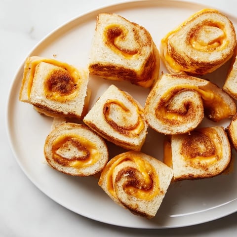 Golden, melty Easy Christmas Grilled Cheese Rollups, perfect for a quick, comforting holiday snack served warm with marinara.