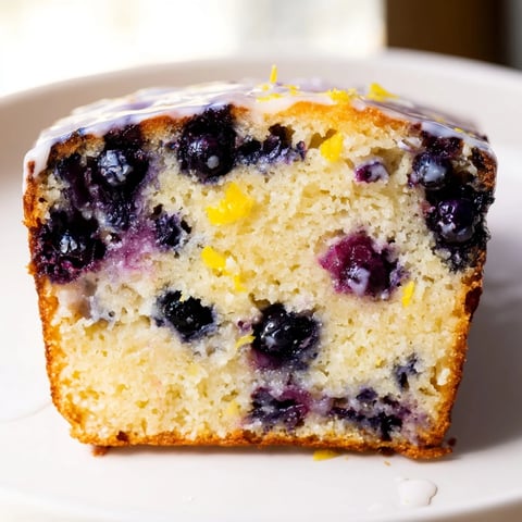 Fluffy Lemon Blueberry Yogurt Loaf, dotted with juicy blueberries, ready to slice and enjoy.