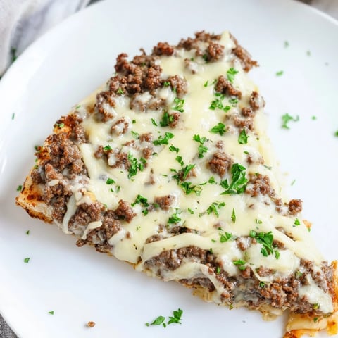 Ground Beef Alfredo Pizza, bubbly mozzarella melting over a savory, seasoned ground beef topping.