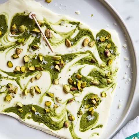 Vibrant Pistachio Matcha White Chocolate bark, swirled with green matcha and topped with crunchy pistachios.