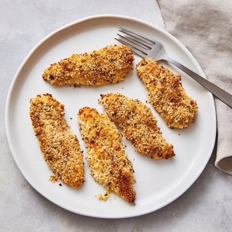 Golden, herbed Crispy Panko Chicken Strips fresh from the oven, glistening and ready for dipping.  