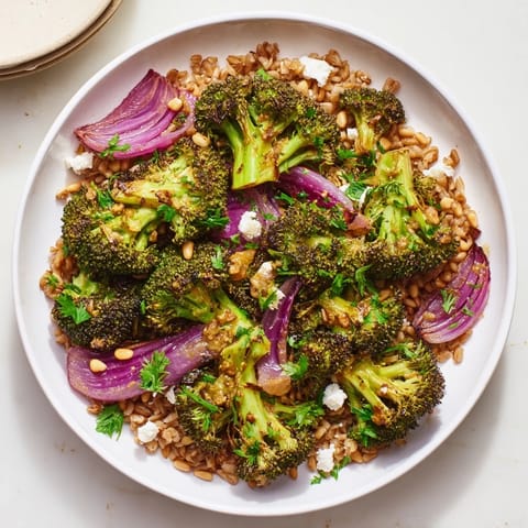 A flavorful bowl of warm roasted broccoli with farro, drizzled with lemon dressing, ready to eat.