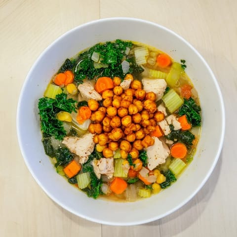 A vibrant close-up depicts hearty Chicken Kale Soup, ready to warm on a chilly day.