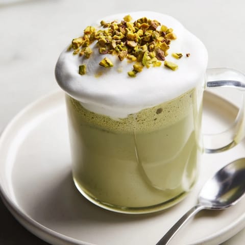 Enjoy a rich, vibrant Pistachio Latte: creamy, frothy, and topped with crunchy pistachios.