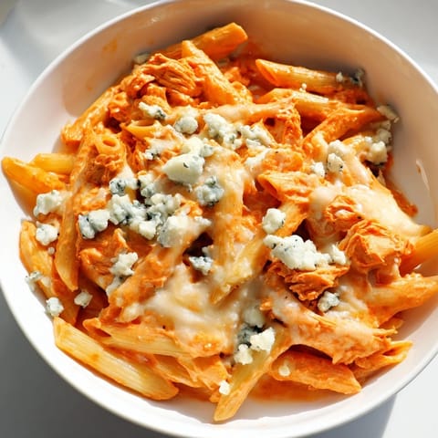 Hearty skillet of buffalo chicken pasta featuring shredded chicken, melty mozzarella, and a smooth, spicy cream sauce ready to serve.  