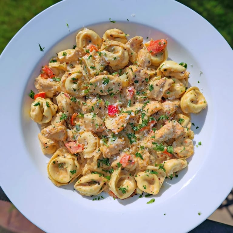 Golden, tender pieces of chicken rest in Zesty Cajun Garlic Parmesan Chicken Tortellini with a creamy, cheesy sauce.