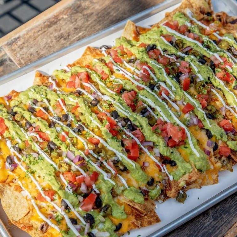 Savory Football Field Nacho Platter with melted cheese, black beans, olives, and fresh toppings ready to serve.