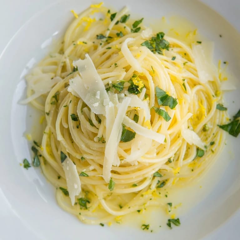 This plate of Lemon Capellini shows angel hair pasta coated with fresh herbs and Parmesan.