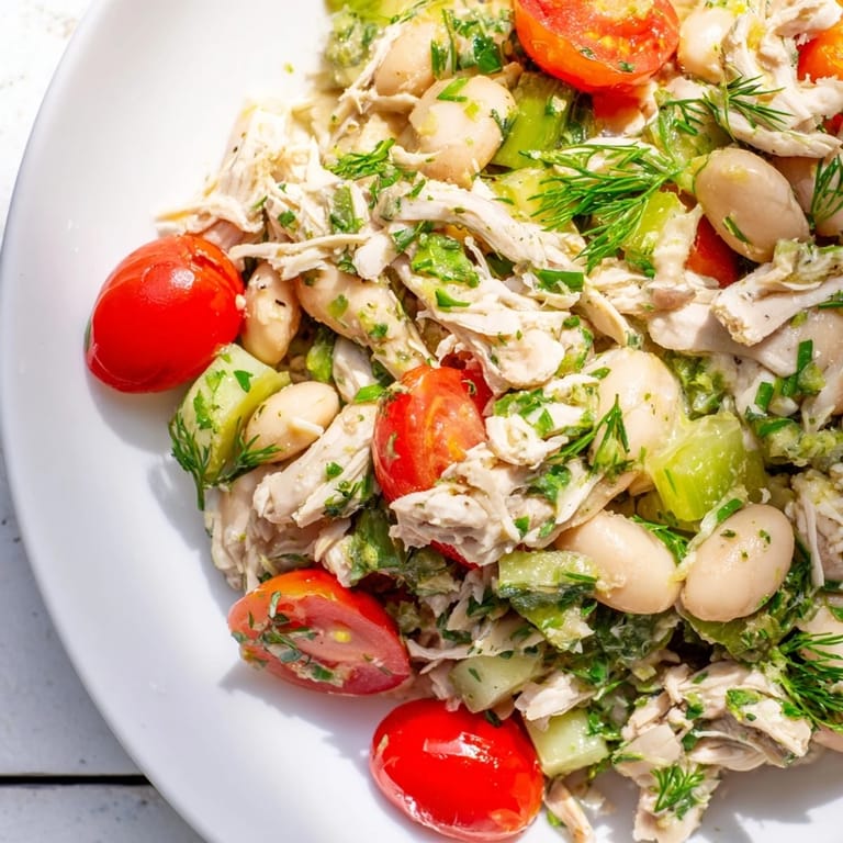 Hearty Lemony White Bean Chicken Salad served in a rustic white bowl, garnished with parsley and lemon zest for a fresh, summery lunch.  