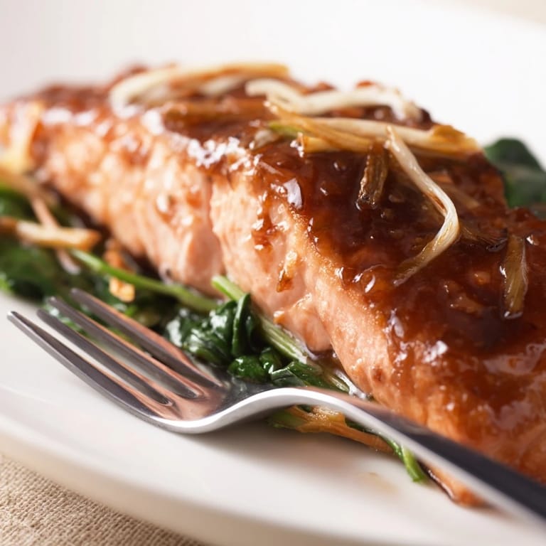 Miso salmon served over a bed of sautéed spinach, ready for a nutritious weeknight dinner.