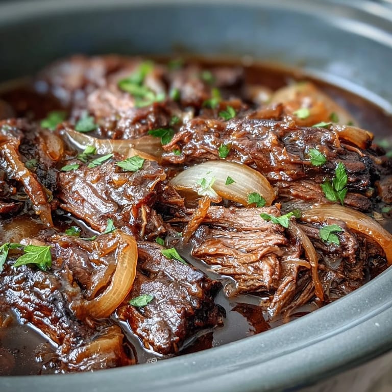 Slow-cooker beef and sweet caramelized onions topped with melted cheese and fresh parsley.